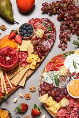 Tahta tabaklar, farklı lezzetli atıştırmalıklar, gri masa, düz uzanmış