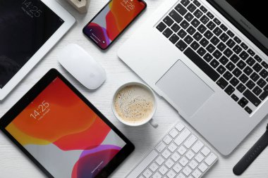 MYKOLAIV, UKRAINE - 28 Ağustos 2020: Beyaz masa üzerinde iPhone 11, MacBook laptop ve iPad tabletleri ile düz kompozisyon