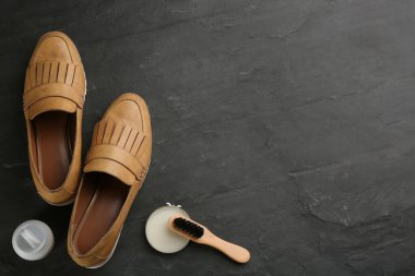 Siyah arka planda ayakkabı bakım aksesuarları ve ayakkabıları olan düz bir kompozisyon. Metin için boşluk