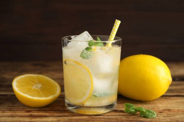 Soğuk taze limonata ve ahşap masada meyveler.