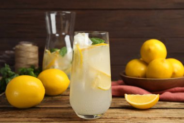 Soğuk taze limonata ve ahşap masada meyveler.