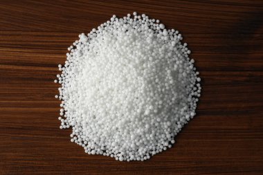 Tahta masanın üzerinde amonyum nitrat tanecikleri var. Mineral gübresi