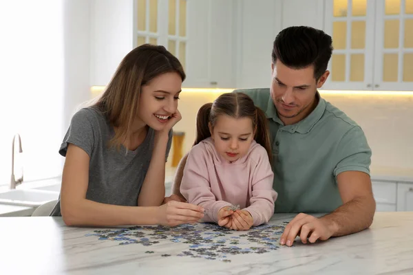 Happy family playing with puzzles at home