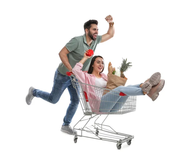 Genç Adam Beyaz Arka Planda Alışveriş Arabasıyla Kız Arkadaşını Gezdiriyor — Stok fotoğraf