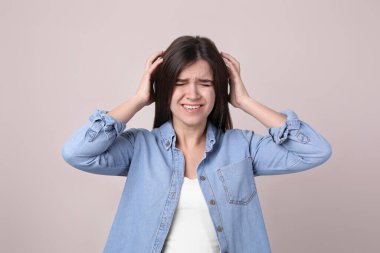 Hafif arka planda stresli genç bir kadının portresi