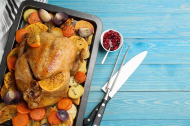 Portakallı ve sebzeli leziz tavuk açık mavi ahşap masa, düz uzanmış