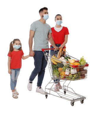 Koruyucu maskeli bir aile ve beyaz arka planda yiyecek dolu alışveriş arabası.