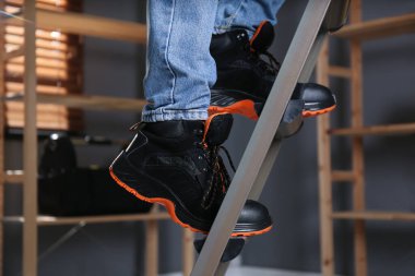 Kapalı alanda merdiven tırmanan, yürüyerek yaklaşan biri.