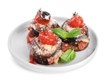 Domatesli fırında patlıcan, peynir ve fesleğen, beyaz tabaklarda izole edilmiş.