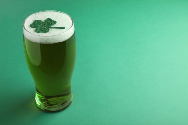 Yeşil arka planda yonca yaprağı olan bir bardak bira, mesaj için yer. Aziz Patrick Günü kutlaması