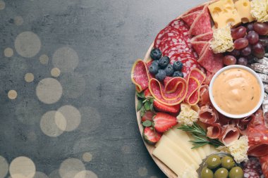 Gri masadaki ahşap tabakta değişik lezzetli atıştırmalıklar, üst manzara. Metin için boşluk