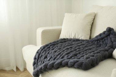 Odadaki kanepede örülmüş merino yün ekose.