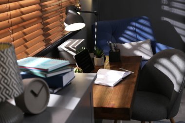 Pencerenin yanında rahat işyeri olan şık bir oda.