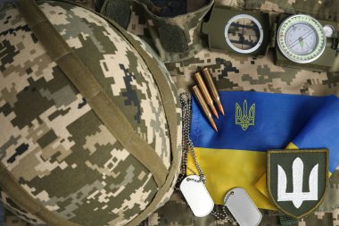 MYKOLAIV, UKRAINE - 26 Eylül 2020: Kamuflaj arka planında taktik teçhizat ve Ukrayna bayrağı