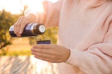 Termostan kapağa sıcak su döken kadın, yakın çekim.