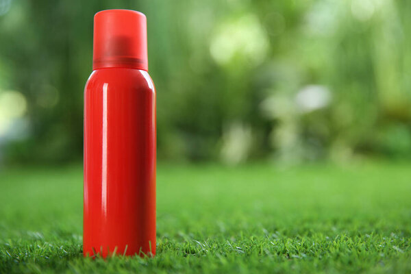 Бутылка спрея от насекомых на зеленой траве. Пространство для текста