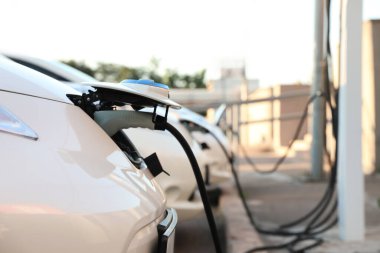 Dışarıdaki istasyondan modern elektrikli arabaları şarj ediyor.