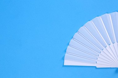 Açık mavi arka planda beyaz el yelpaze, üst manzara. Metin için boşluk