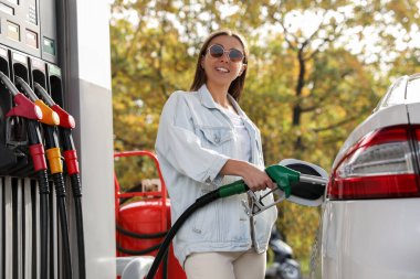 Benzin istasyonunda yakıt ikmali yapan kadın.