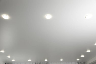 Beyaz tavan, içeride lambalar var.