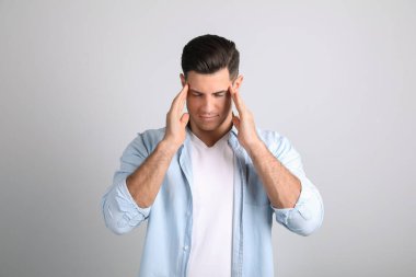 Adam arka planda şakaklarını ovuyor. Stres atma.