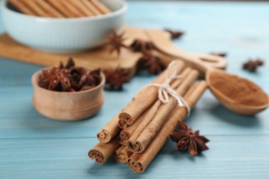 Aromatik tarçın ve anason açık mavi ahşap masada, yakın plan.