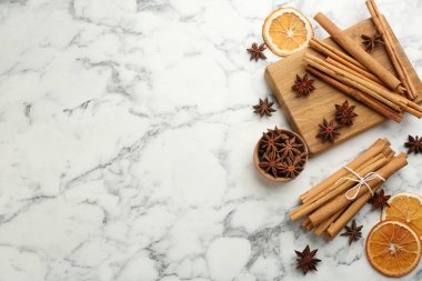 Aromatik tarçın çubukları, kuru turuncu ve beyaz mermer masa üzerinde anason. Metin için boşluk