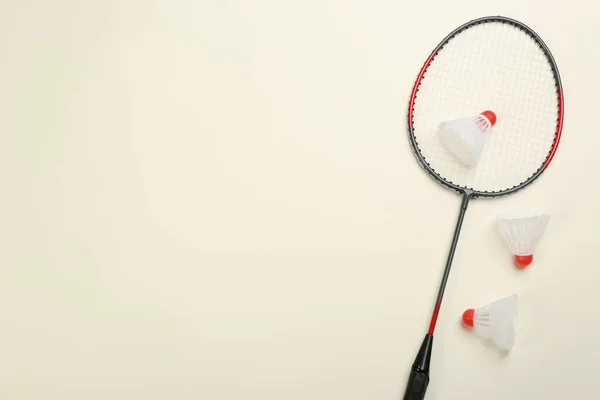 球拍和羽毛球在米色背景上 平铺着文字的空间 羽毛球的装备 — 图库照片