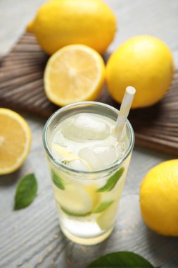 Soğuk taze limonata ve gri ahşap masada meyveler.