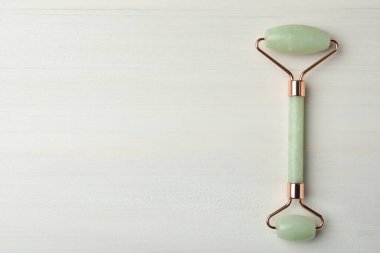 Beyaz ahşap arka planda doğal yeşim taşlı yüz silindiri, üst manzara. Metin için boşluk