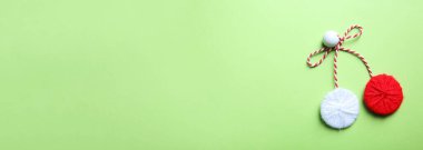 Yeşil zemin üzerinde geleneksel martisor, metin için boşluk ile üst görünüm. Bahar kutlaması başlıyor.