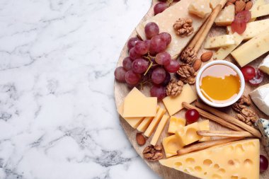 Ballı peynir tabağı, beyaz mermer masada üzüm ve fındık, üst manzara. Metin için boşluk