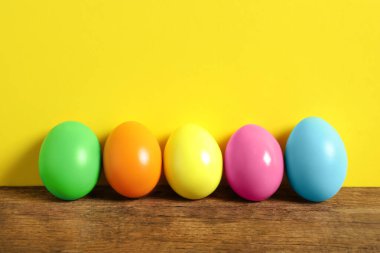 Ahşap masada sarı arka planda Paskalya yumurtaları