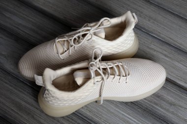 Ahşap arka planda bağcıkları olan şık ayakkabılar.