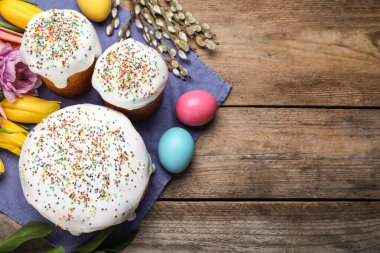 Tahta masanın üzerinde Paskalya pastaları olan düz bir kompozisyon. Metin için boşluk