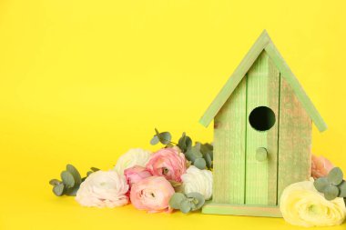 Şık bir kuş evi ve sarı arka planda taze mutluluklar. Metin için boşluk