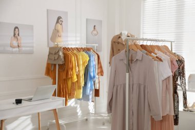 Moda giysileri ve dizüstü bilgisayarı olan modern bir butik.