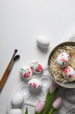 Paskalya yumurtalarını beyaz masaya boyamak.