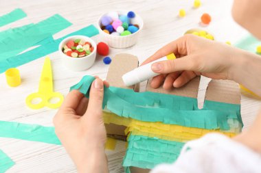 Beyaz ahşap masada karton kaktüs dekore eden kadın, yakın plan. Pinata DIY