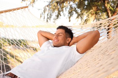Sahilde hamakta dinlenen bir adam. Yaz tatili