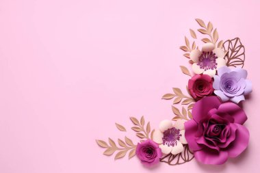 Farklı güzel çiçekler ve pembe arka planda kağıttan dallar, düz bir zemin. Metin için boşluk