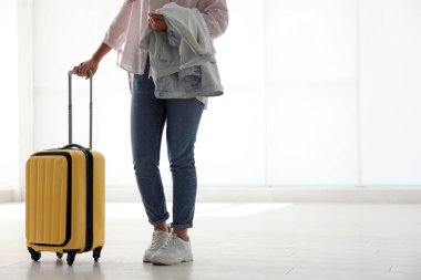 Havaalanında sarı valizli bir kadın. Metin için boşluk