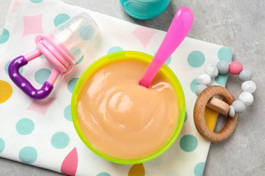 Gri masadaki sağlıklı bebek mamasıyla düz bir kompozisyon.