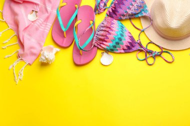 Sarı arka planda plaj aksesuarları, düz yatış. Metin için boşluk