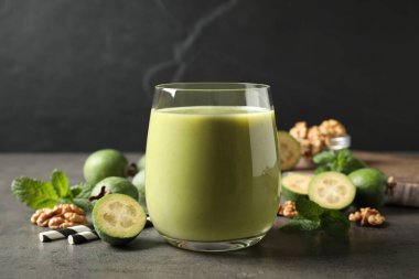 Gri masada cam içinde taze feijoa smoothie.