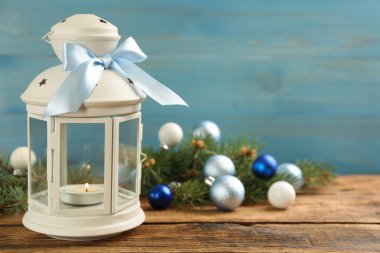 Yanan mumlu Noel feneri ve ahşap masada şenlikli bir dekor. Metin için boşluk