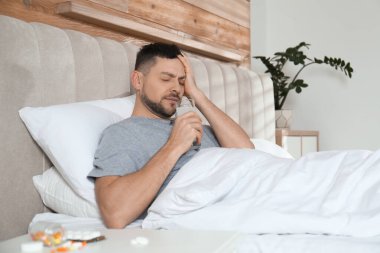 Adam akşamdan kalmalık için evde ilaç alıyor.