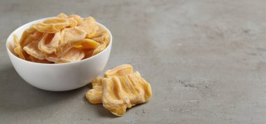 Açık gri masada lezzetli kurutulmuş meyve dilimleri. Metin için boşluk