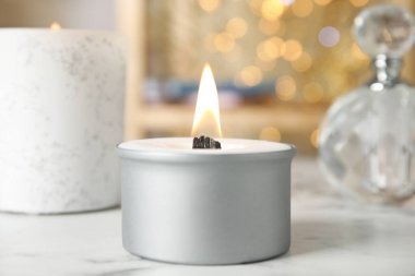 Beyaz masada yanan mum ve ahşap fitil.