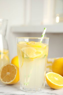 Serin taze limonata ve beyaz mermer masada meyveler.